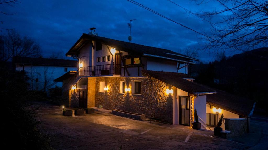 Una casa iluminada por la noche con luces encendidas en Adaka, en Oiartzun