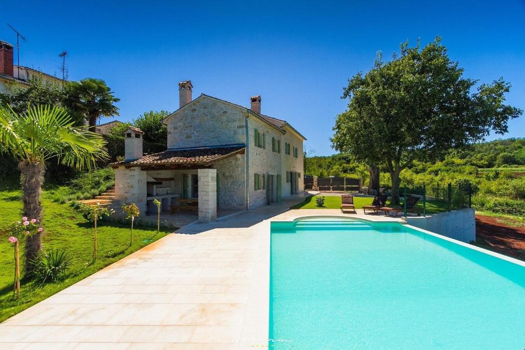 una grande piscina davanti a una casa di Villa Zvonar near Motovun with large pool and whirlpool a Rakotule