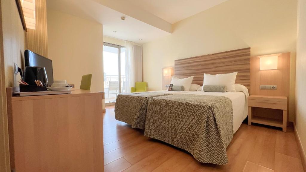 ベニドルムにあるRiviera Beachotel - Adults Recommendedのベッドとテレビが備わるホテルルームです。