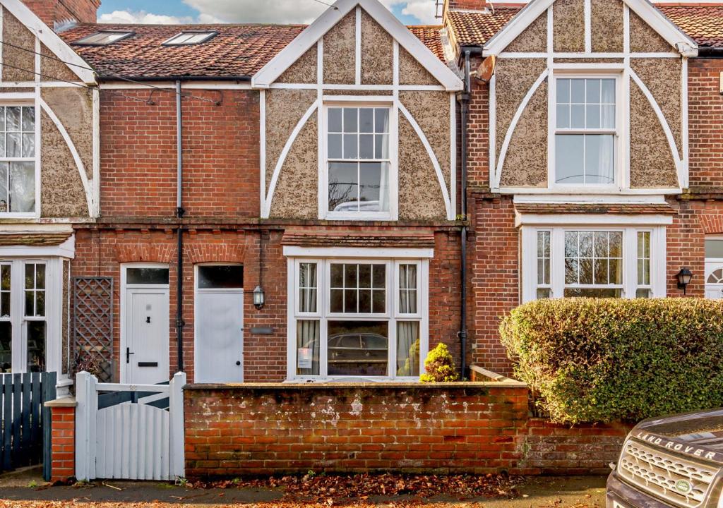 a brick house with white doors and windows at Bond Cottage in Overstrand