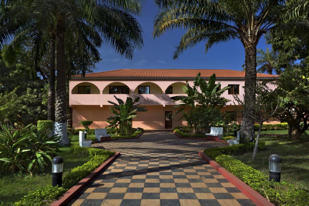 a resort building with a checkerboardkered driveway at Dunia Hôtel Bissau in Bissau