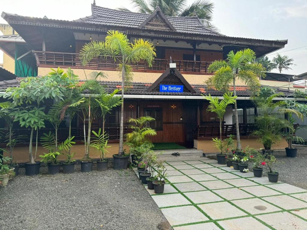 un edificio con palmeras delante en HERITAGE HOMES en Ernakulam