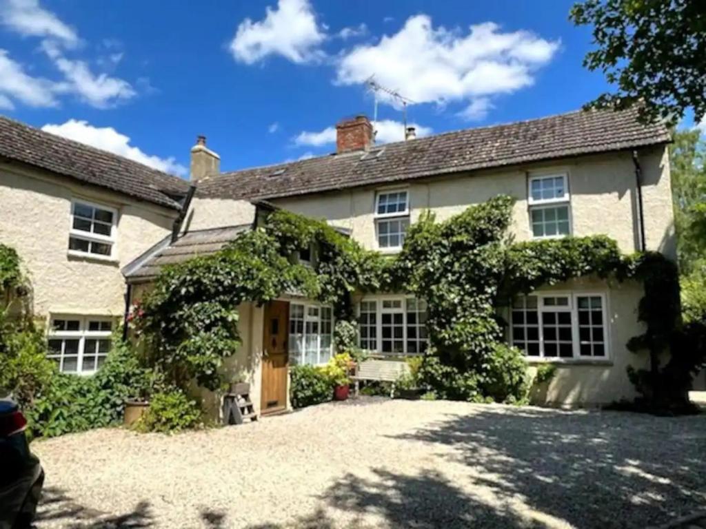 an exterior view of a house with a driveway at Pass the Keys Stylish and Spacious Cotswolds Cottage - Sleeps 6 in Lechlade