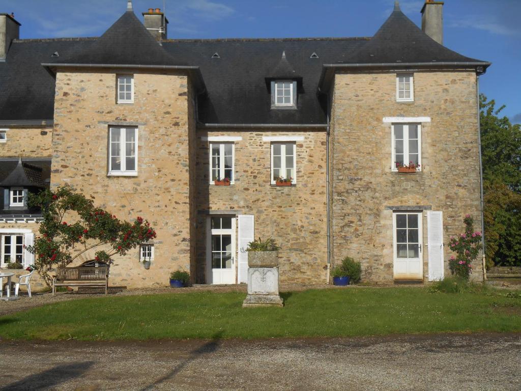 un grande edificio in mattoni con porte e finestre bianche di Au Presbytère de Dagmar a Erbrée