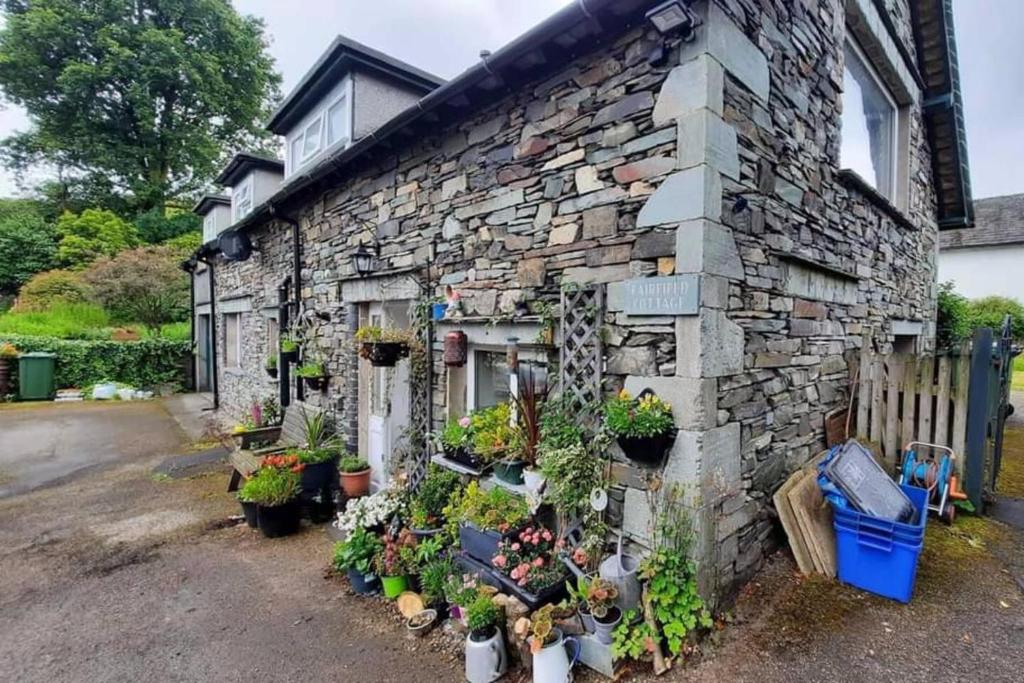 a stone building with potted plants on it at Cosy cottage in picturesque Hawkshead in Hawkshead