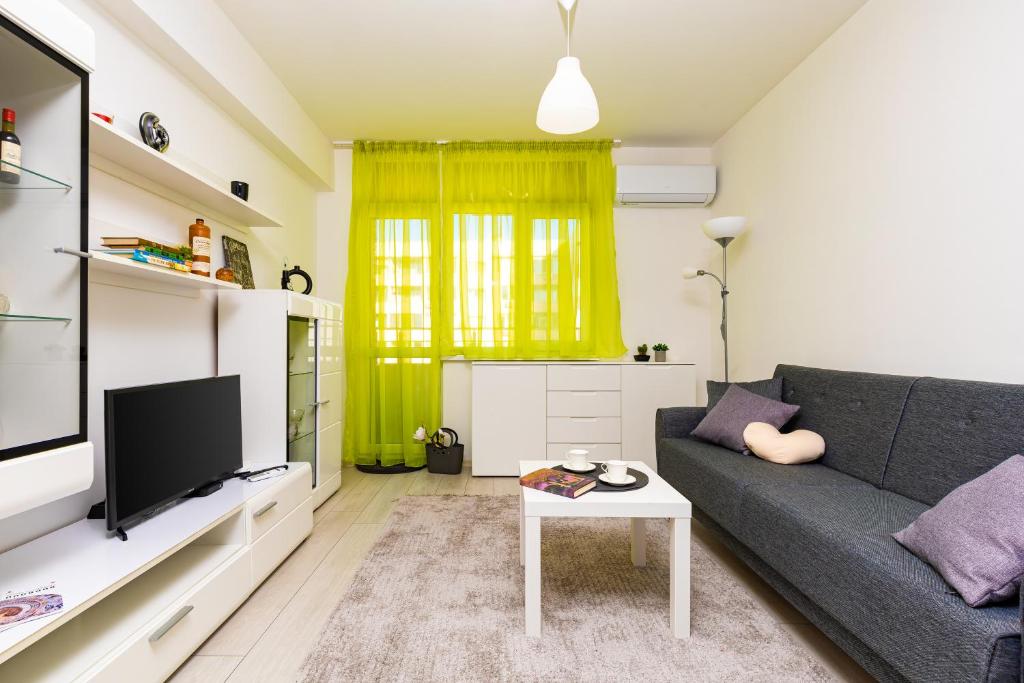 a living room with a couch and a tv at Radiant Retreat: Bright 1BD Haven in Plovdiv in Plovdiv