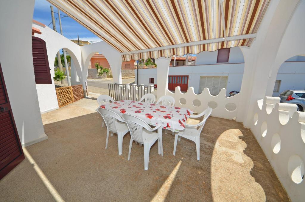 een witte tafel en stoelen op een patio bij GINESTRA 3 in Marina di Pescoluse