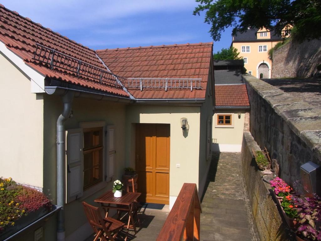 ein kleines Haus mit einer Terrasse und einem Tisch in der Unterkunft Ferienhaus Rentsch in Rudolstadt