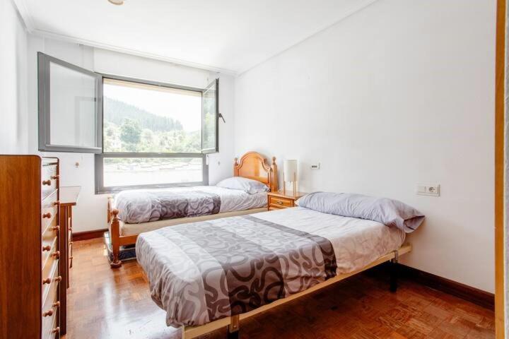 a bedroom with two beds and a window at Luminosa habitación in Mondragón