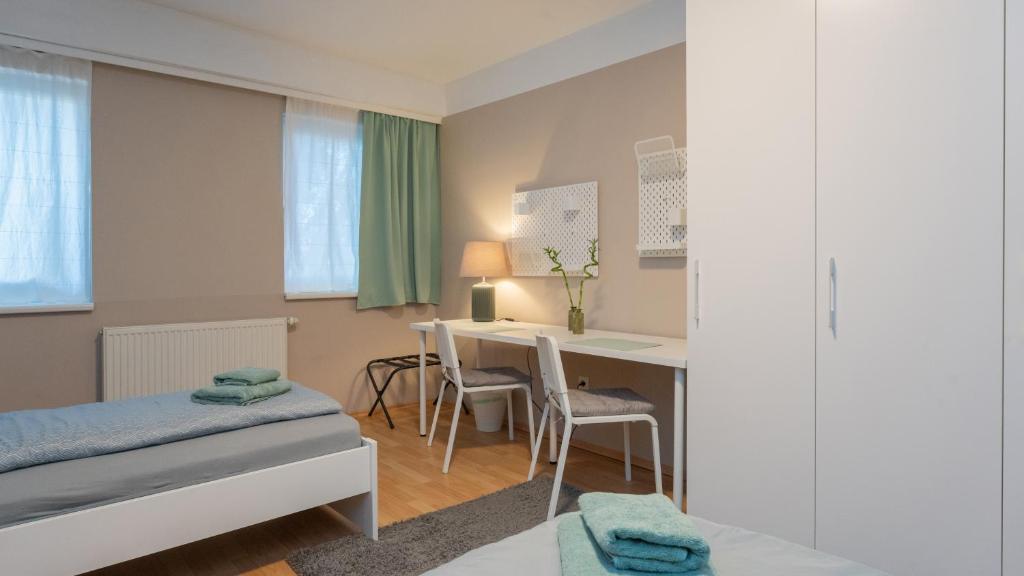 Zimmer 1230 في فيينا: غرفة نوم مع مكتب وسرير وطاولة
