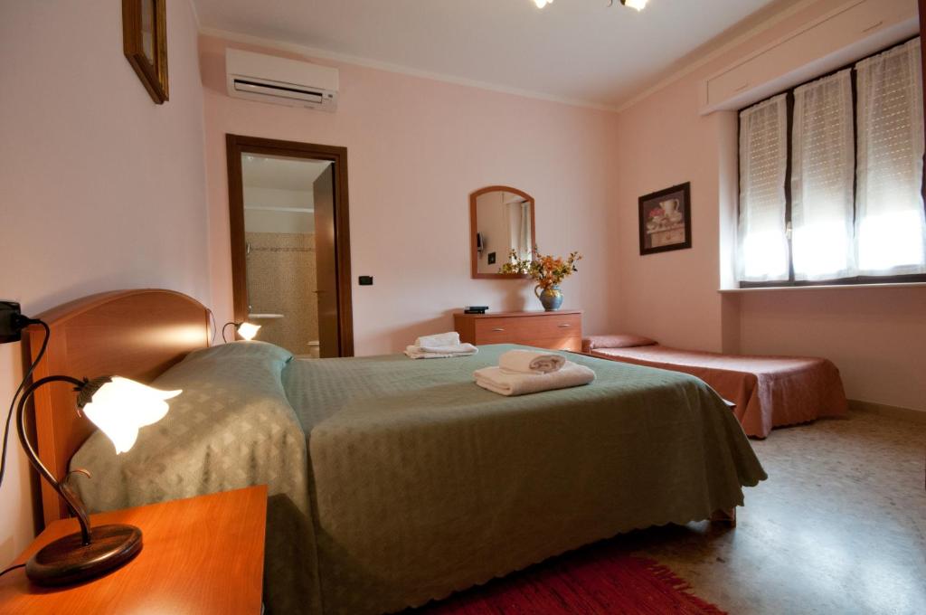 a bedroom with two beds and a lamp and a mirror at Agriturismo Il Crinale in Castorano