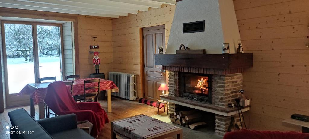 sala de estar con chimenea y mesa en Grimont gîte au calme grand terrain circuit cascades du Hérisson, en Saugeot