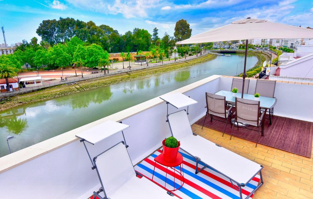 einen Balkon mit einem Tisch, Stühlen und einem Fluss in der Unterkunft Apartamento Guadiana RÍA - Centro in Ayamonte