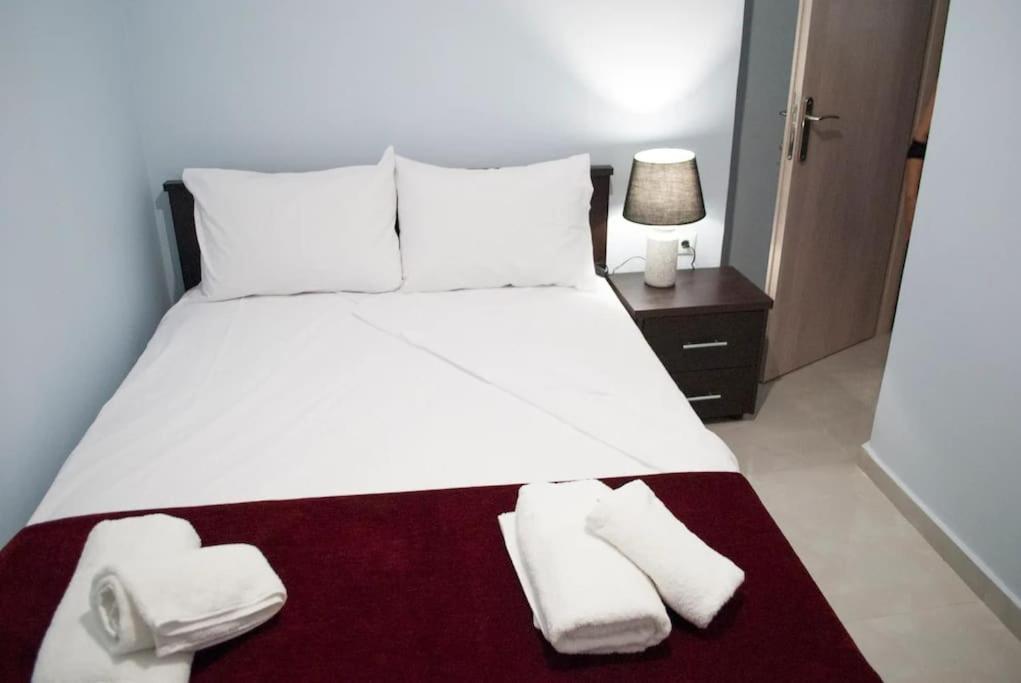 - une chambre avec un grand lit blanc et des serviettes dans l'établissement Kostas Cozy Charming Appartment, à Thessalonique