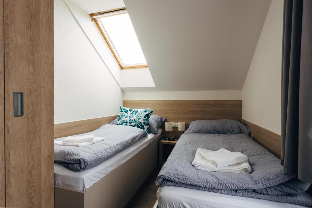 2 Betten in einem kleinen Zimmer mit Fenster in der Unterkunft Ubytování Kytín in Kytín
