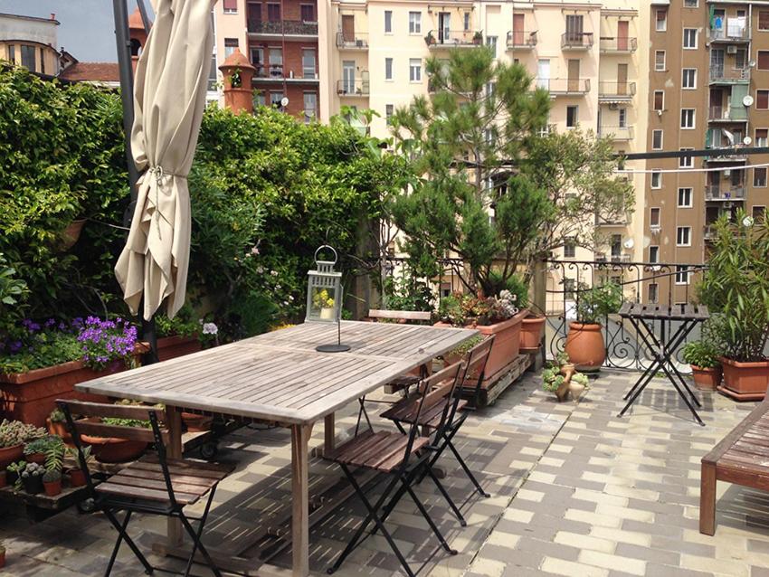 a wooden table and chairs on a patio at Best Way Rent - Old Kramer in Milan