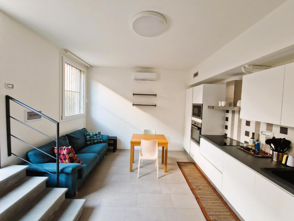 un salon avec un canapé bleu et une table dans l'établissement MonteRoom-Apartments, à Bologne