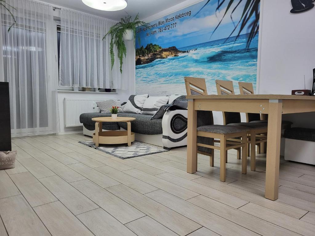 sala de estar con mesa y sillas en LUX Apartamenty Bliżej Morza Kołobrzeg, en Kołobrzeg