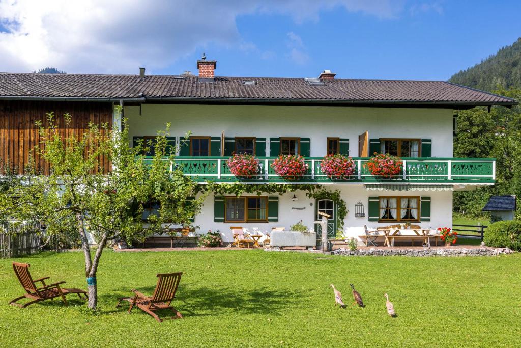 a house with a balcony and birds in the yard at Bindenhäusl - Ramsau in Ramsau