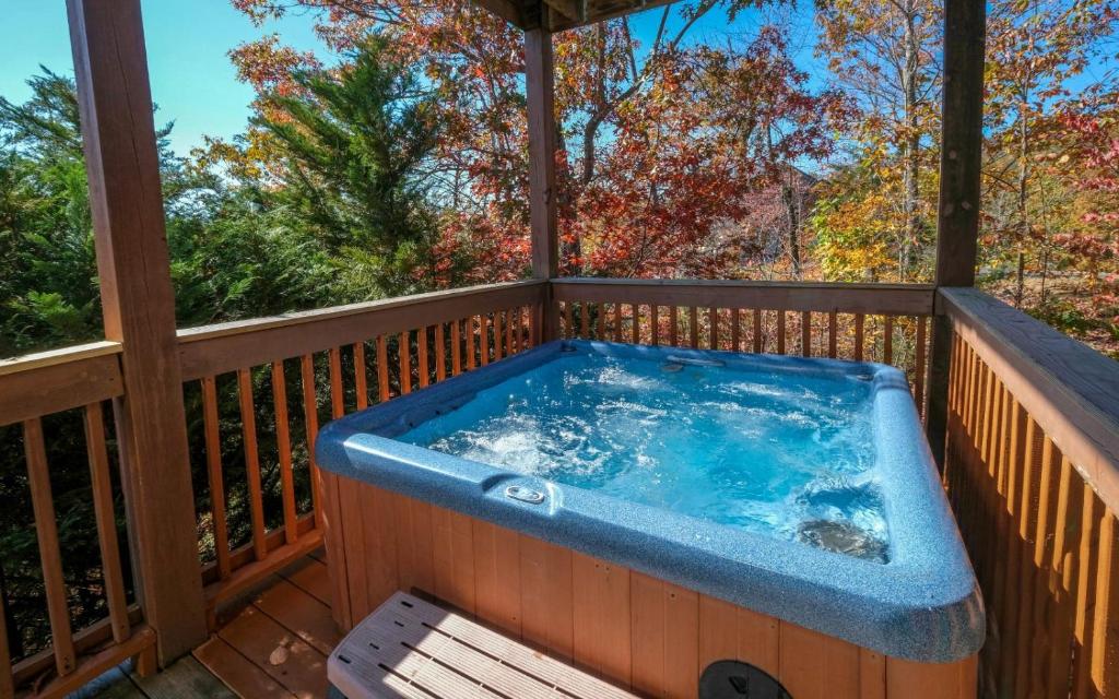 bañera de hidromasaje en la cubierta de una casa en Moonlit Hideaway, en Sevierville