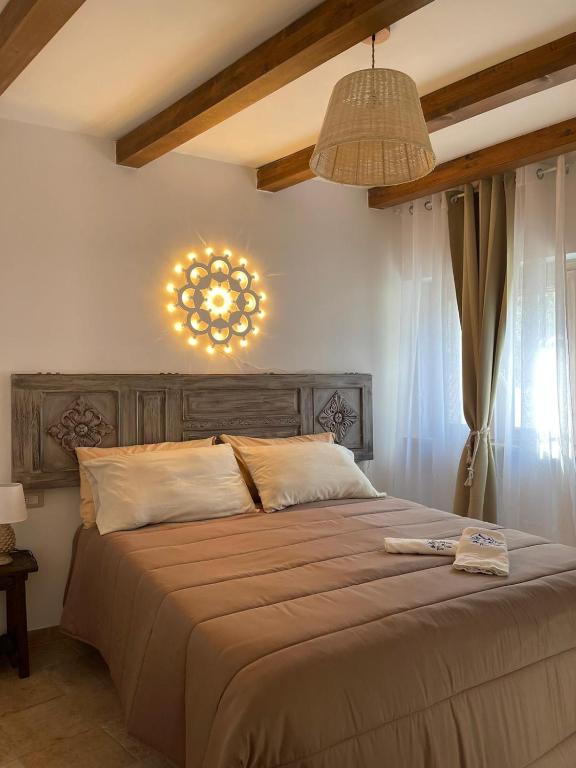 1 dormitorio con 1 cama grande y lámpara de araña en Trullo Santa Lucia, en Cisternino
