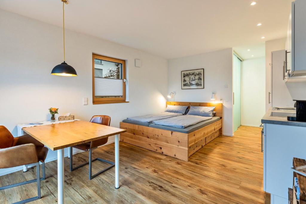 a bedroom with a bed and a wooden table at Ferienwohnung Sonnenhalde in Moos