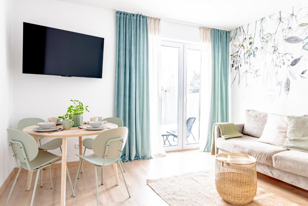 uma sala de estar com uma mesa e um sofá em Apartamenty Sea Colors - Nowoczesne i Komfortowe Apartamenty w Jastrzębiej Górze em Jastrzebia Gora