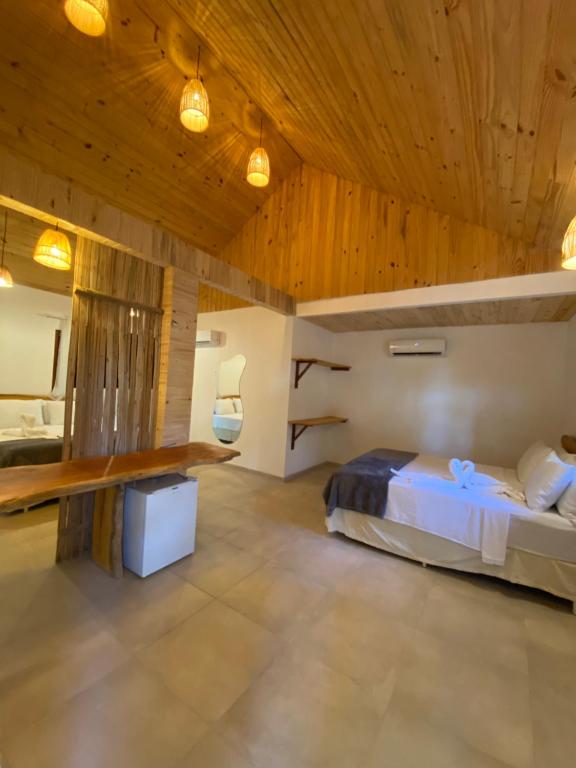 ジャパラティンガにあるPousada Corais do Bitinguiの木製の天井が特徴のベッドルーム1室(ベッド1台付)