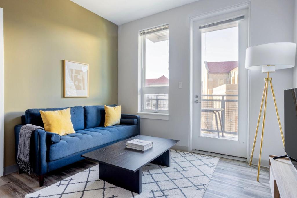 a living room with a blue couch and a table at Brighton 2br w gym nr green line dining BOS-982 in Boston