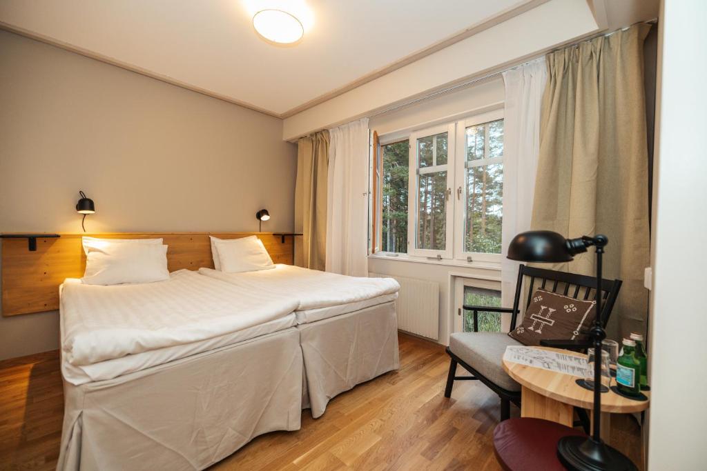 - une chambre avec un lit, une chaise et une fenêtre dans l'établissement Barken Lodge, à Smedjebacken