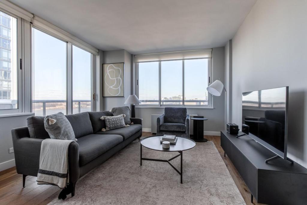 a living room with a couch and a tv at Midtown West 2br w gym roofdeck nr Hudson NYC-1395 in New York