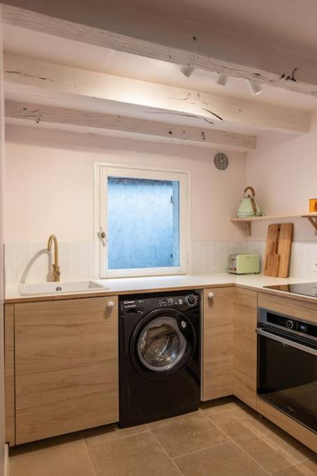 une cuisine avec un lave-linge et une fenêtre dans l&#39;établissement Duplex avec patio - Quartier historique, à Moulins