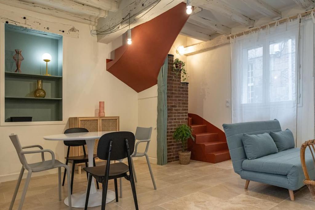 - un salon avec un canapé bleu, une table et des chaises dans l&#39;établissement Duplex avec patio - Quartier historique, à Moulins