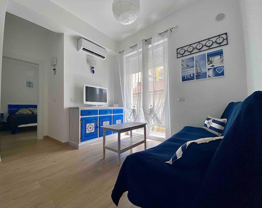 sala de estar con sofá azul y mesa en Cuore d’Orlando apartment, en Capo dʼOrlando