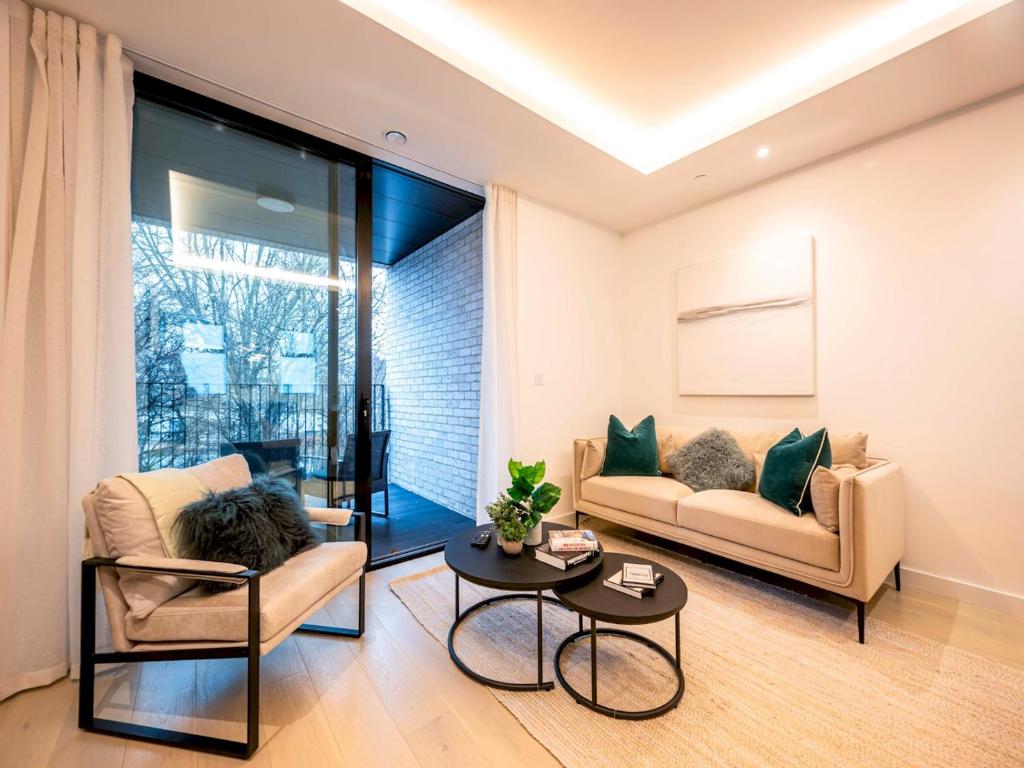 uma sala de estar com um sofá e uma mesa em Pass the Keys Modern Exuberance and Luxury at Lucent House em Londres