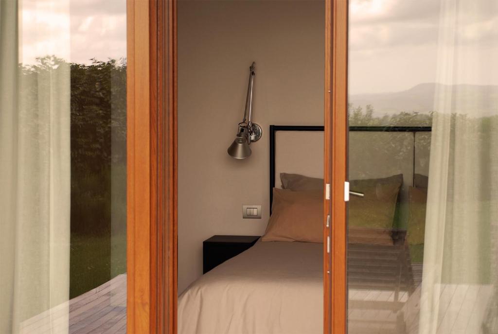 a glass door leading to a bedroom with a bed at Poggio Cagnano in Manciano