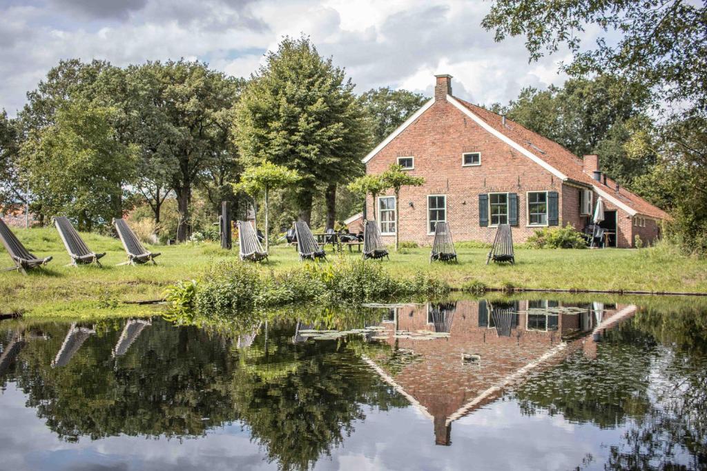 um grupo de cadeiras sentadas ao lado de uma massa de água em De Staakenborgh em Bourtange