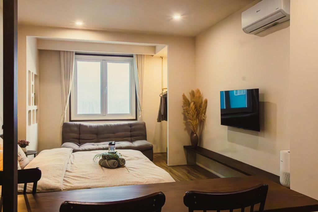a living room with a bed and a television at Areca Boutique Apartments Hanoi in Hanoi