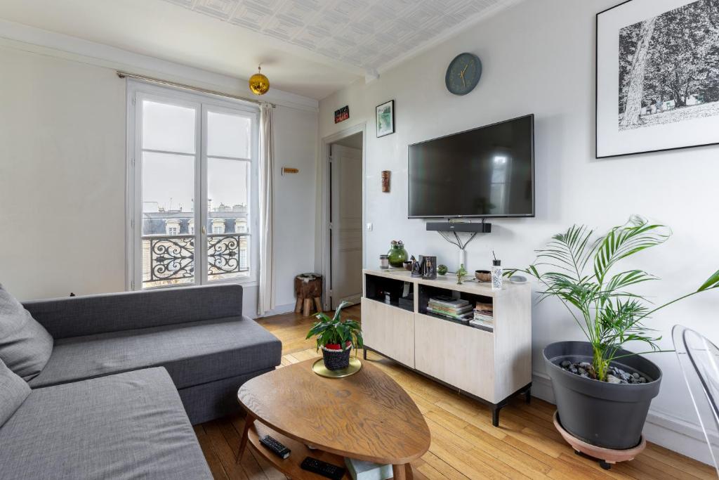 un salon avec un canapé et une télévision à écran plat dans l'établissement Paris - Le Marais, Vue Magnifique, sans vis-à-vis., à Paris