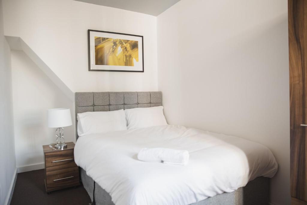 1 dormitorio con cama blanca y mesita de noche en Leicester Park House, en Leicester