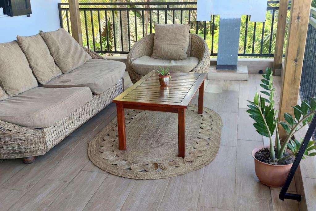 a living room with a couch and a coffee table at Les lataniers 1 - Vue sur mer in Saint-Pierre