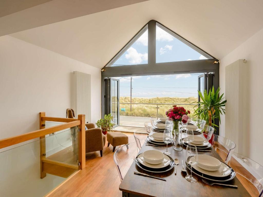 a dining room with a table and a large window at 4 Bed in New Romney 88208 in Greatstone