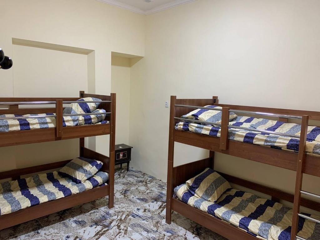 a room with three bunk beds in a room at ADORA HOSTEl in Tashkent