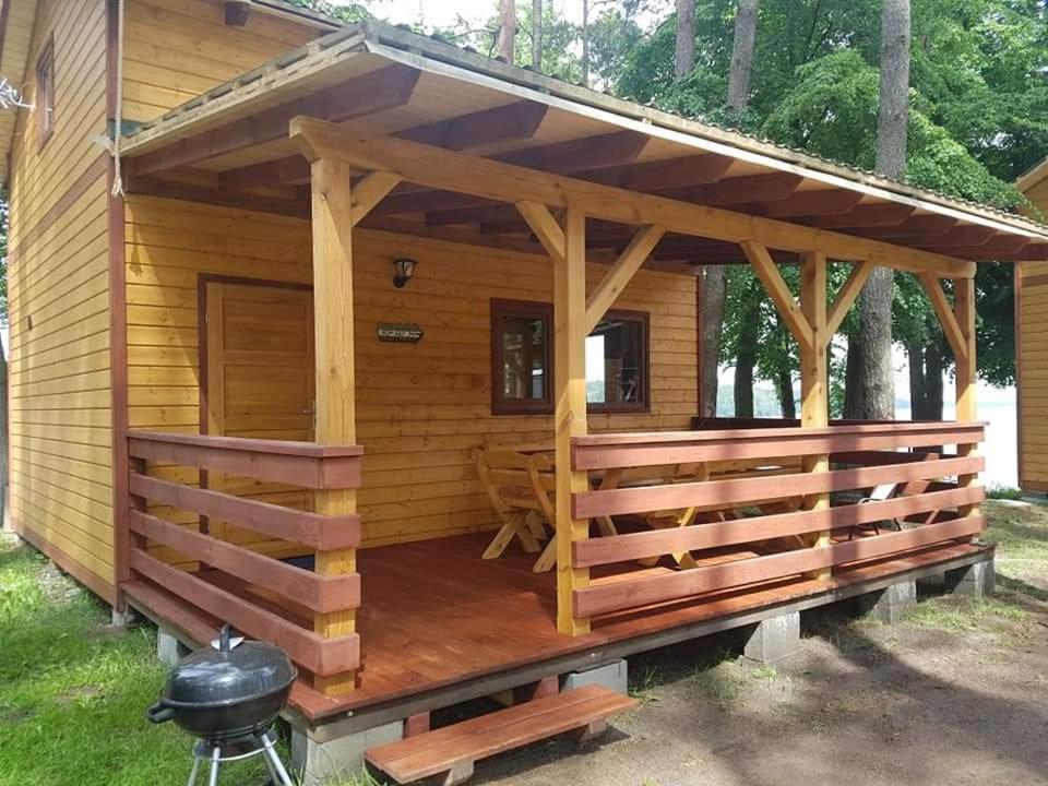 a log cabin with a porch and a grill at Ośrodek Krasnal Makowo in Iława