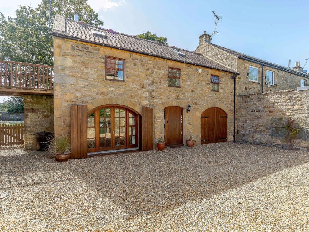 an old stone house with wooden doors and a balcony at 2 Bed in Hexham 88443 in Acomb