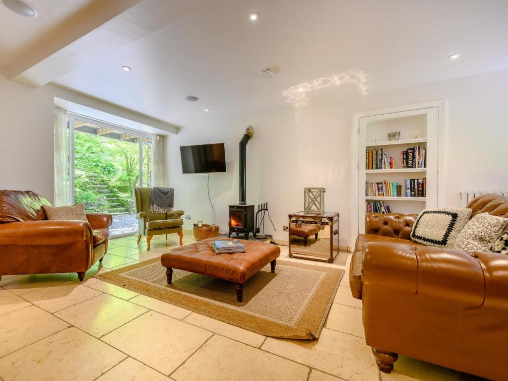 a living room with leather furniture and a fireplace at 2 Bed in Cunsey 88319 in Far Sawrey