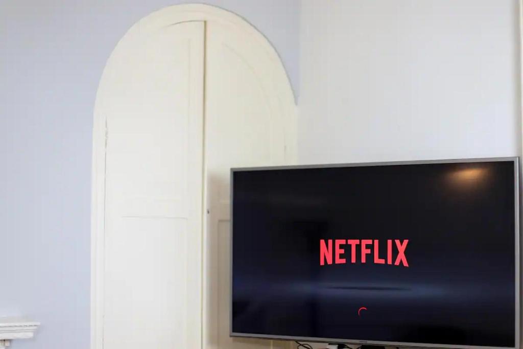 a tv with a netflix sign on a wall at Stunning Georgian Spacious Apartment Central Bath in Bath