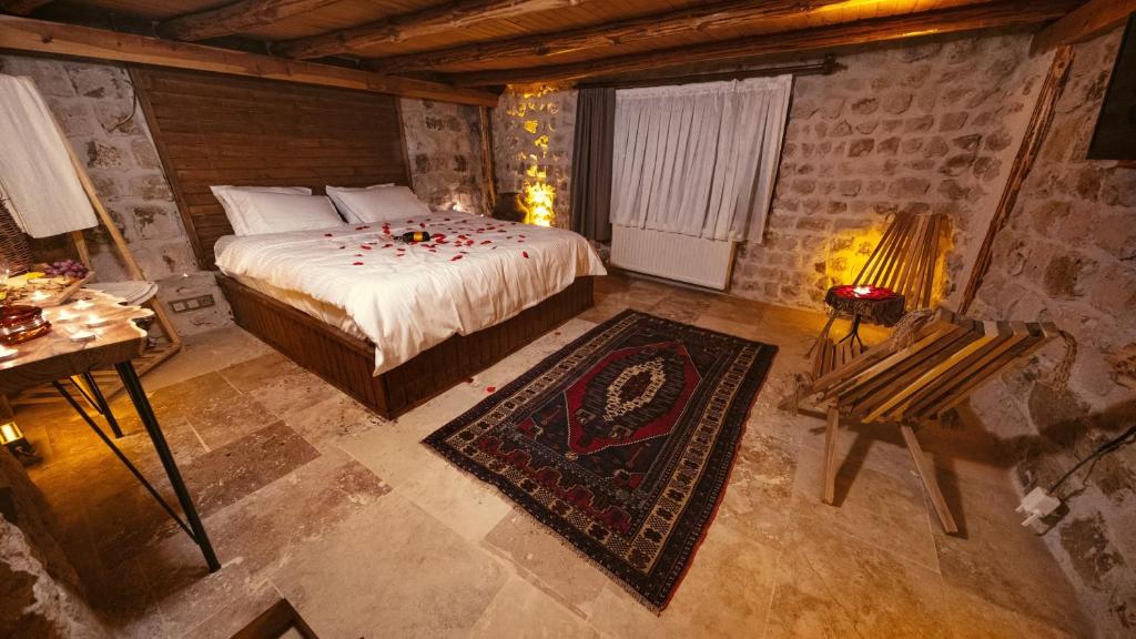 a bedroom with a bed and a table with a lamp at crassula cave kapadokya hotel in Nar