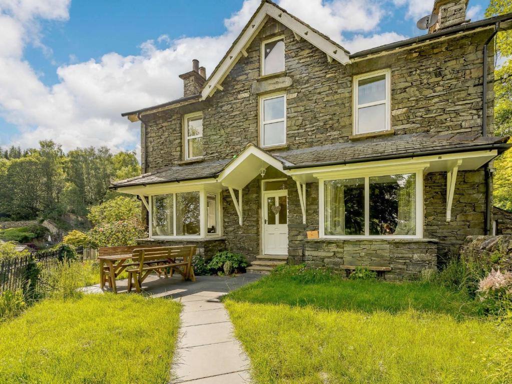 una casa de piedra con mesa de picnic y banco en 3 bed property in Cunsey Lake District 88769, en Far Sawrey