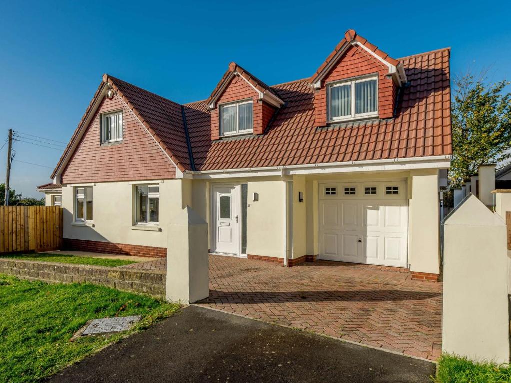 a house with a red roof and white garage at 4 Bed in Braunton 89603 in Braunton
